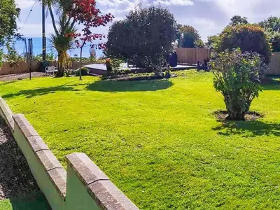 a yard with green grass and a fence at 2 Northbank Cottages in Whiting Bay