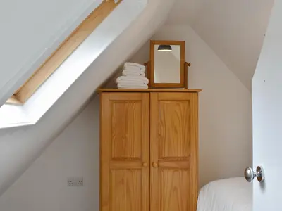 a mirror on top of a wooden cabinet in a attic at Ivy Cottage in Whiting Bay