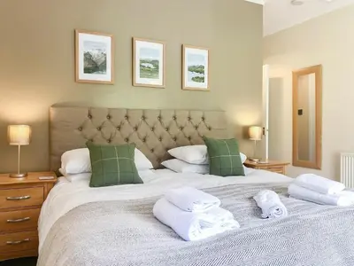 a bedroom with a large bed with towels on it at Oakvale - Acorn in Braithwaite