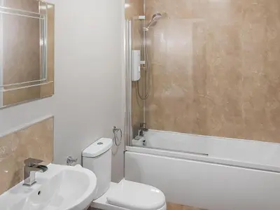 a bathroom with a toilet and a sink and a shower at Cumberland Place in Keswick