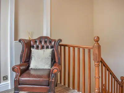 a leather chair with a pillow on a staircase at Cumberland Place in Keswick