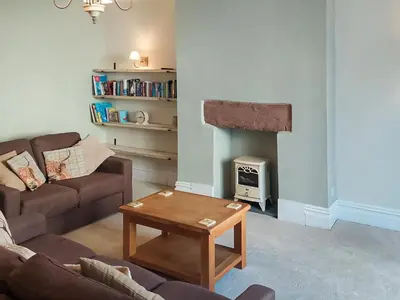 a living room with a couch and a fireplace at Cumberland Place in Keswick