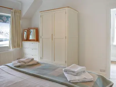 a bedroom with a large white cabinet and two towels at Cumberland Place in Keswick