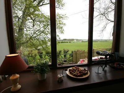 a table with a plate of food in front of a window at Rowan Cottage in Borgue