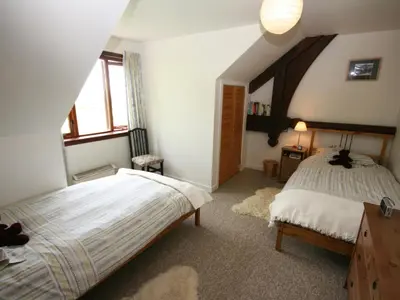 a bedroom with a bed and a window at Rowan Cottage in Borgue