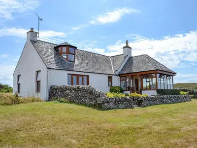 a white house with a stone wall at Allanhead in Borgue