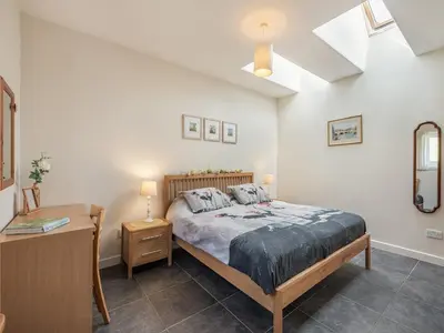 a bedroom with a bed and a dresser and a table at Strathmaddie Farm Cottage in Palnure