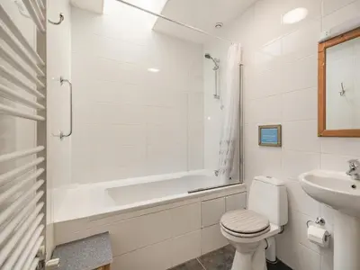 a white bathroom with a toilet and a sink at Strathmaddie Farm Cottage in Palnure