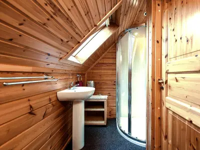 a bathroom with a sink in a wooden wall at Criffel Lodge in Ringford