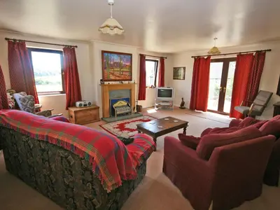 a living room with two couches and a fireplace at Rocky Knowe in Dalbeattie