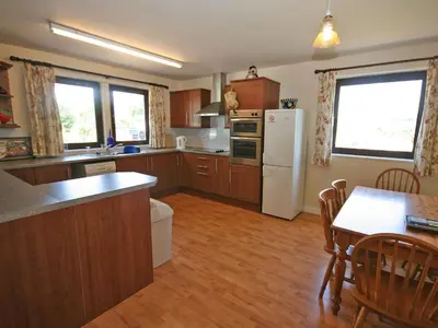 a kitchen with wooden cabinets and a white refrigerator at Rocky Knowe in Dalbeattie