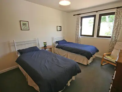 a bedroom with two beds and a window at Rocky Knowe in Dalbeattie