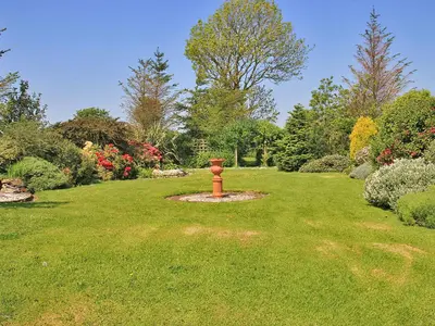 a garden with a fire hydrant in the middle of a lawn at Palmallet Cottage in Whithorn