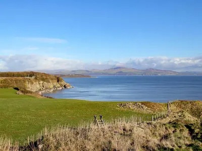 a view of a body of water with a fence at Palmallet Cottage in Whithorn