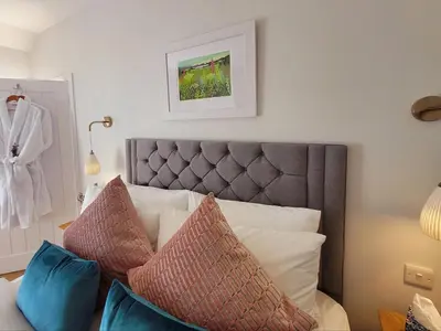 a bedroom with a bed with pillows on it at Palmallet Cottage in Whithorn