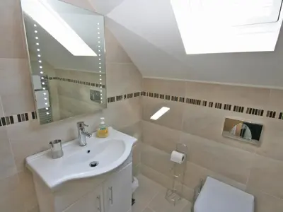 a bathroom with a sink and a mirror and a toilet at Cairndoon Steading Whithorn in Carleton