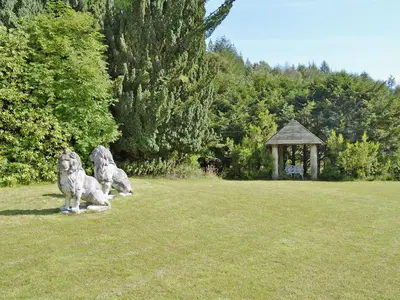 two dogs sitting in a field with a gazebo at Squirrel Cottage in Palnure