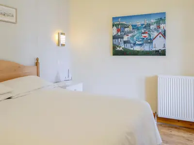 a bedroom with a white bed and a picture on the wall at Dorn Rock View - Uk33918 in Portpatrick
