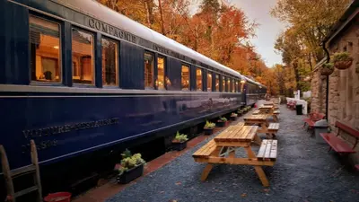 a blue train parked next to a row of wooden tables at Pheasant Lodge Scottish Borders in Carlisle