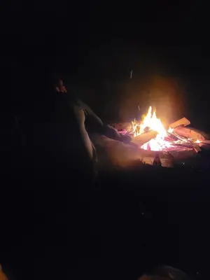 a person is standing next to a fire at night at Large country house with garden, outdoor spa area & games room with Hot Tub and Fire Pit in Wigtown