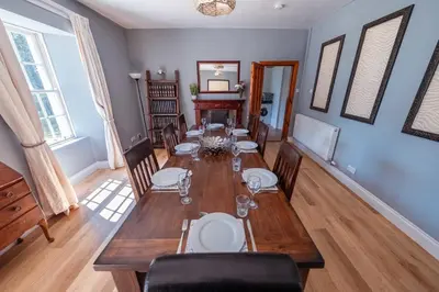 a dining room with a table and chairs at Large country house with garden, outdoor spa area & games room with Hot Tub and Fire Pit in Wigtown