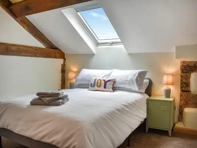 a bedroom with a white bed with a skylight at Pickles Barn in Ireby