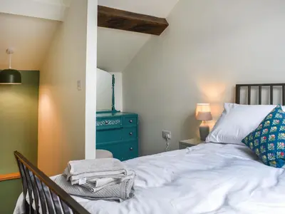 a bedroom with a bed and a blue dresser at Pickles Barn in Ireby