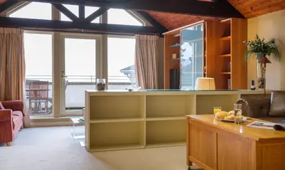 a living room with a table and some windows at Underscar - Littledale in Keswick