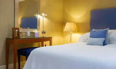 a bedroom with a bed and a desk with a mirror at Underscar - Littledale in Keswick
