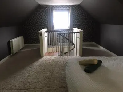 a bedroom with a bed and a window and a stair case at Brig O'Doon 1 in Ayr