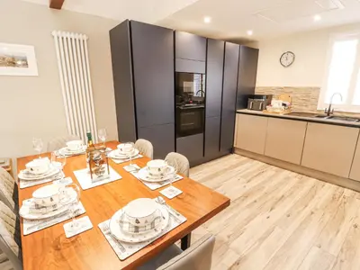 a kitchen and dining room with a wooden table at Squirrel Cottage in Penrith