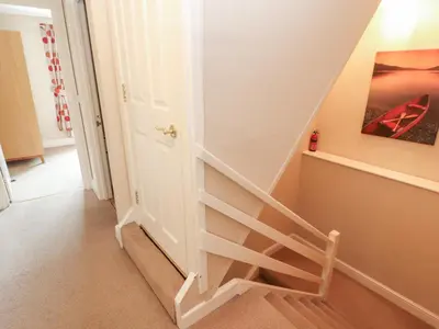 a staircase in a home with a white stair case at Lillibet Cottage in Keswick