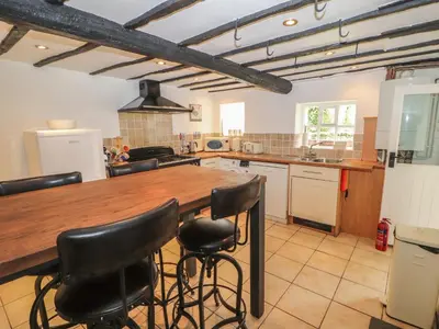 a kitchen with a wooden table and black chairs at Lillibet Cottage in Keswick