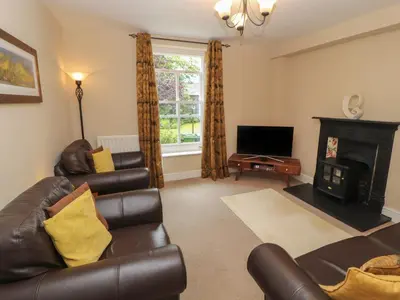 a living room with leather furniture and a fireplace at Lillibet Cottage in Keswick