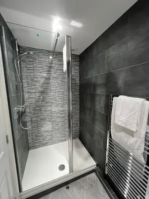 a bathroom with a shower with a glass door at The Globe Apartments and Bedrooms in Cockermouth