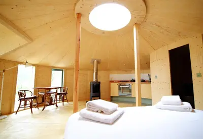 a room with two beds and a kitchen in a room at Otter - Eco Bothy with Hot Tub in Castle Douglas
