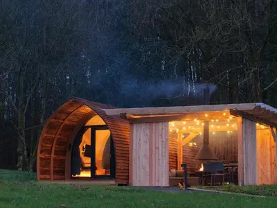 a small cabin with a wooden roof at night at Glencartholm Farm by Wigwam Holidays in Canonbie