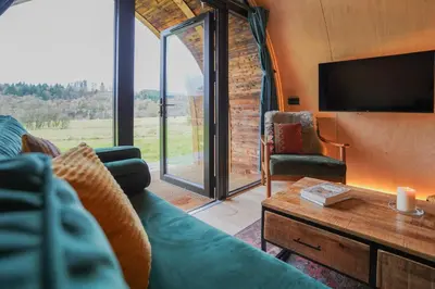 a living room with a couch and a tv at Glencartholm Farm by Wigwam Holidays in Canonbie