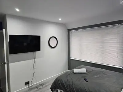 a bedroom with a bed and a clock on the wall at Bridgepay Modern 4 bedroom House in Cumbria - Whitehaven - Free Parking in Whitehaven