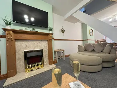 a living room with a couch and a fireplace with a flat screen tv at Bolton Terrace - 2 Bedrooms - Sleeps 4 in Workington