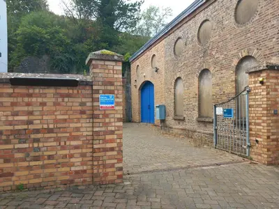 a brick building with a blue door and a gate at Harbour View - 1 Bedroom - Sleeps 2 in Whitehaven