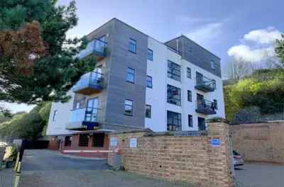 a large white building with a brick wall at Harbour View - 1 Bedroom - Sleeps 2 in Whitehaven