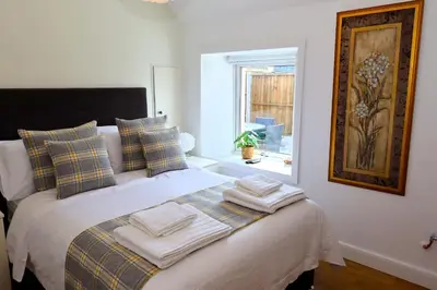a bedroom with a bed with two towels on it at Tigh Samhradh in Monreith