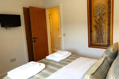 a bedroom with a bed with two towels on it at Tigh Samhradh in Monreith