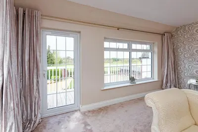 a bedroom with two large windows and a chair at Brig o Doon 2 in Ayr