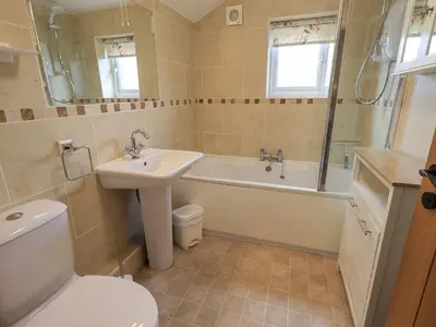 a bathroom with a sink and a tub and a toilet at Hollens Cottage in Ambleside