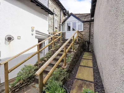 a wooden stairway leading up to a house at Hollens Cottage in Ambleside