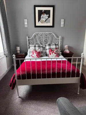 a bedroom with a bed with a pink blanket at Ecclefechan Hotel in Ecclefechan