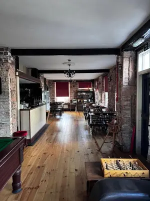 a living room with tables and chairs and a pool table at Ecclefechan Hotel in Ecclefechan