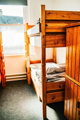 a bedroom with two bunk beds and a window at Denton House Hostel in Keswick